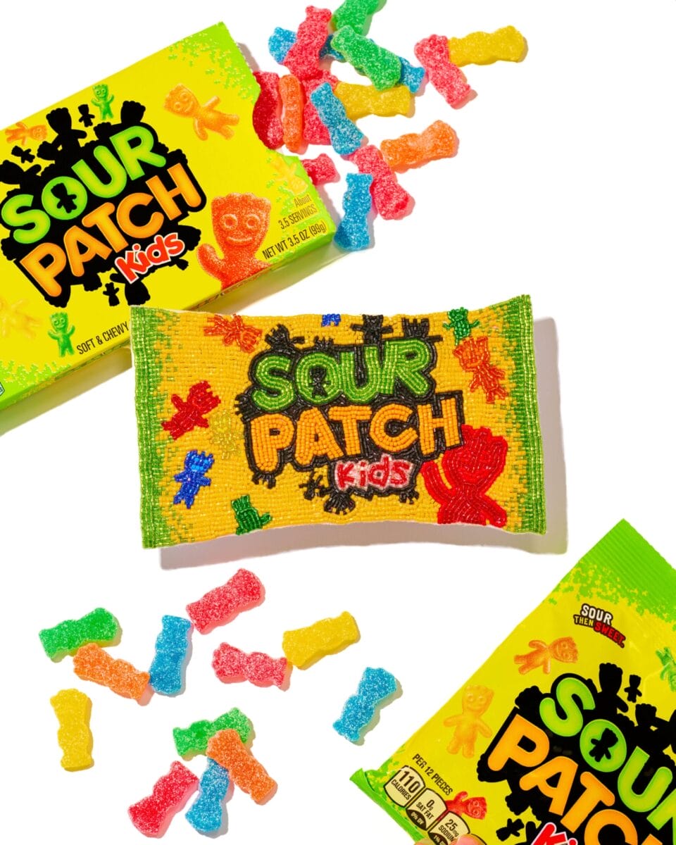 a beaded depiction of a Sour Patch Kids bag surrounded by real bags and real gummy candies