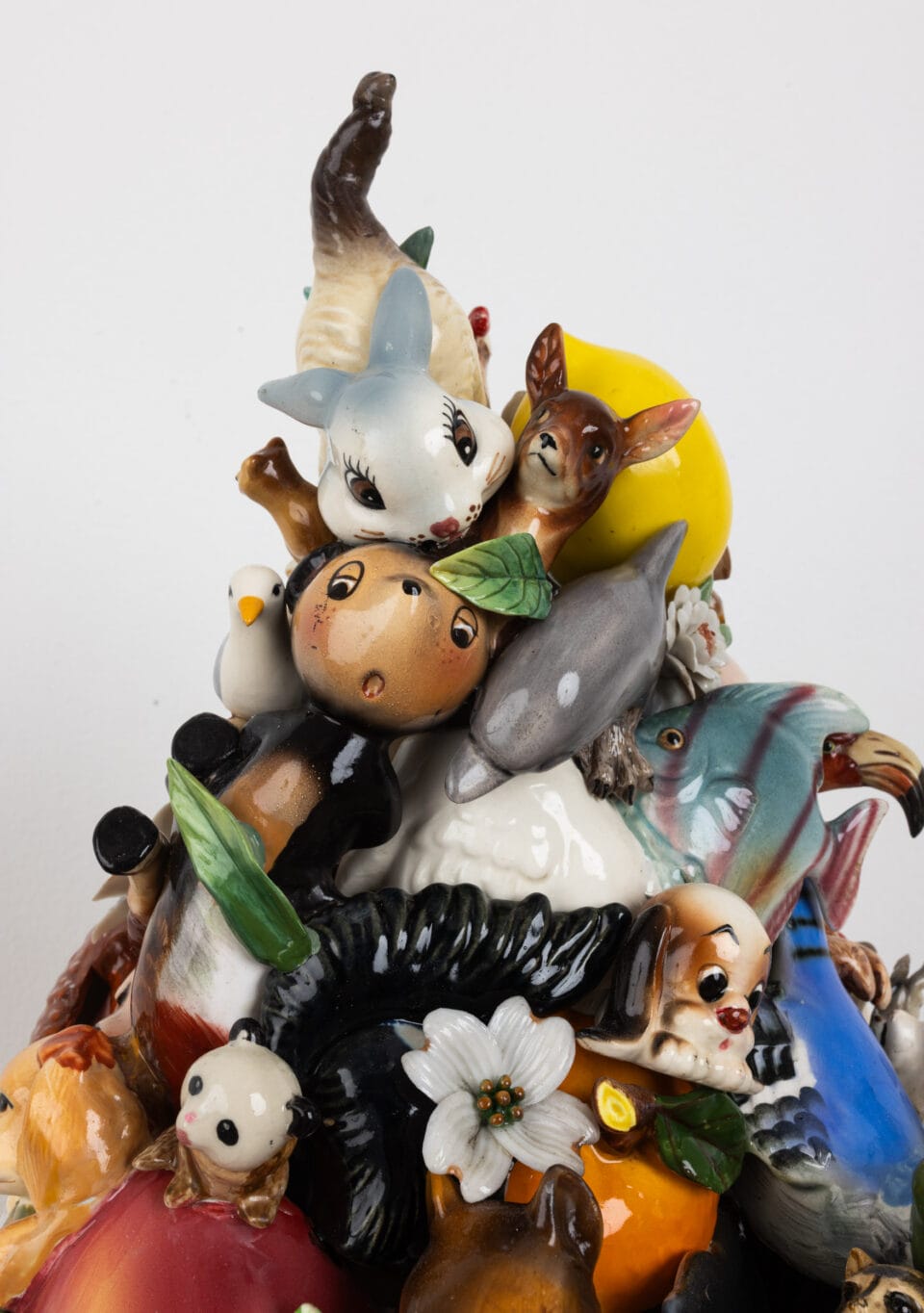 small ceramic objects and animals assembled together into a cone shape